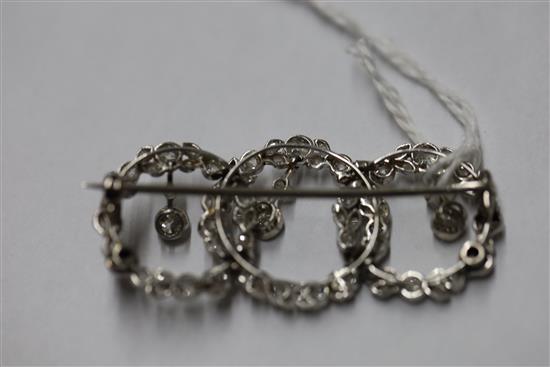 A 1920s white gold and diamond set interlocking triple circle openwork drop brooch,